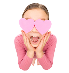 Image showing Little girl is holding hearts over her eyes