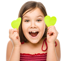 Image showing Little girl is holding hearts near her eyes