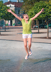 Image showing Girl is running through fountains