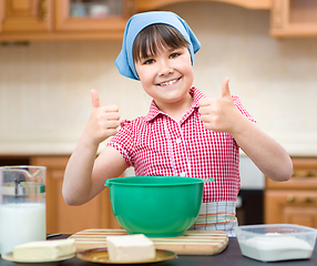 Image showing Girl is cooking in kitchen