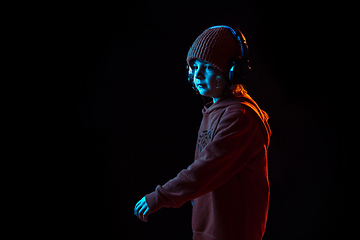 Image showing Caucasian boy\'s portrait isolated on dark studio background in neon light