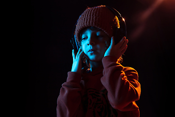 Image showing Caucasian boy\'s portrait isolated on dark studio background in neon light