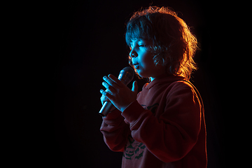 Image showing Caucasian boy\'s portrait isolated on dark studio background in neon light