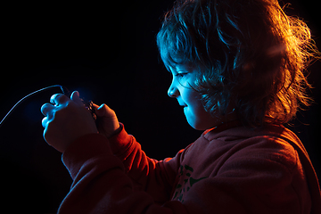 Image showing Caucasian boy\'s portrait isolated on dark studio background in neon light