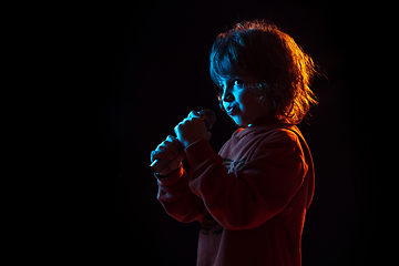 Image showing Caucasian boy\'s portrait isolated on dark studio background in neon light