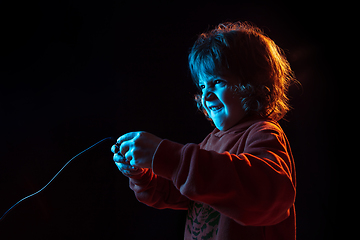 Image showing Caucasian boy\'s portrait isolated on dark studio background in neon light