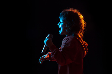 Image showing Caucasian boy\'s portrait isolated on dark studio background in neon light