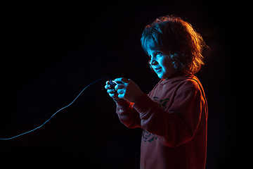 Image showing Caucasian boy\'s portrait isolated on dark studio background in neon light