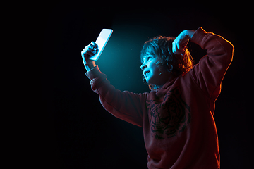 Image showing Caucasian boy\'s portrait isolated on dark studio background in neon light