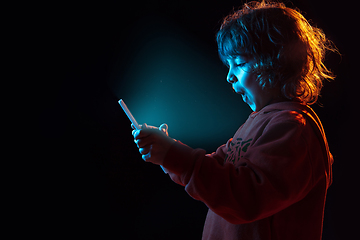 Image showing Caucasian boy\'s portrait isolated on dark studio background in neon light