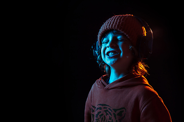 Image showing Caucasian boy\'s portrait isolated on dark studio background in neon light