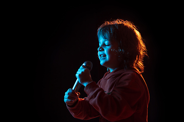 Image showing Caucasian boy\'s portrait isolated on dark studio background in neon light