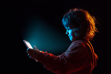 Image showing Caucasian boy\'s portrait isolated on dark studio background in neon light