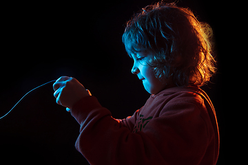 Image showing Caucasian boy\'s portrait isolated on dark studio background in neon light