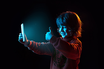 Image showing Caucasian boy\'s portrait isolated on dark studio background in neon light