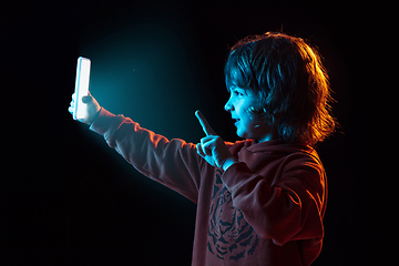 Image showing Caucasian boy\'s portrait isolated on dark studio background in neon light