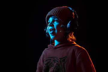 Image showing Caucasian boy\'s portrait isolated on dark studio background in neon light