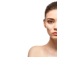 Image showing beautiful girl applying powder on face isolated on white