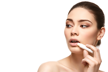 Image showing girl applying pink lipstick isolated on white