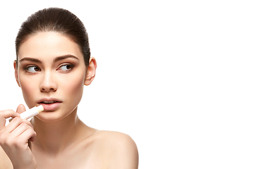 Image showing girl applying pink lipstick isolated on white