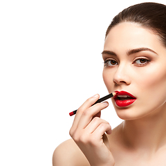Image showing girl applying red lipstick isolated on white
