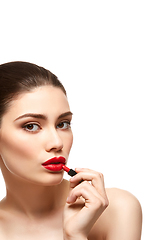 Image showing girl applying red lipstick isolated on white
