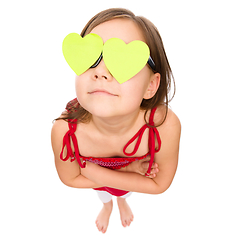 Image showing Little girl is holding hearts over her eyes