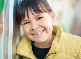 Image showing Portrait of a girl leaning to the wall