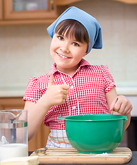 Image showing Girl is cooking in kitchen