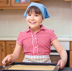 Image showing Girl is cooking in kitchen