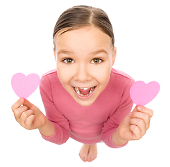 Image showing Little girl is holding hearts near her eyes