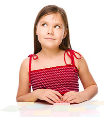 Image showing Girl is writing on color stickers using pen