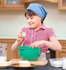 Image showing Girl is cooking in kitchen
