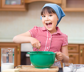 Image showing Girl is cooking in kitchen