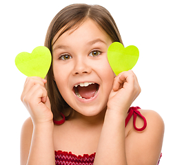 Image showing Little girl is holding hearts near her eyes