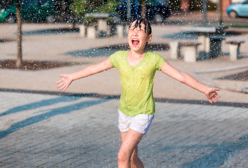 Image showing Girl is running through fountains