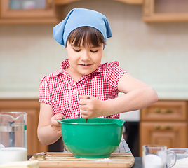 Image showing Girl is cooking in kitchen