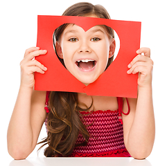 Image showing Little girl is looking through heart template