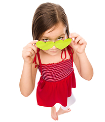 Image showing Girl is looking over her heart-shaped glasses