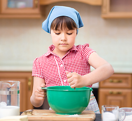 Image showing Girl is cooking in kitchen