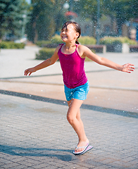 Image showing Girl is running through fountains