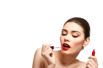 Image showing girl applying red lipstick isolated on white