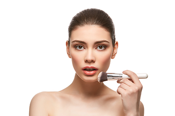 Image showing girl applying foundation on face isolated on white