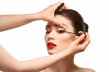 Image showing girl applying eyelash mascara isolated on white