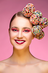 Image showing beautiful girl with candies on pink backgroound