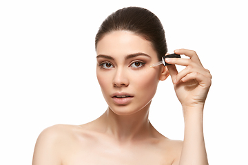 Image showing girl applying eye serum isolated on white