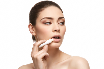 Image showing girl applying pink lipstick isolated on white