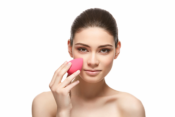 Image showing girl with makeup sponge isolated on white