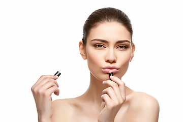 Image showing girl applying pink lipstick isolated on white