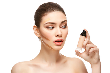 Image showing girl applying foundation on face isolated on white